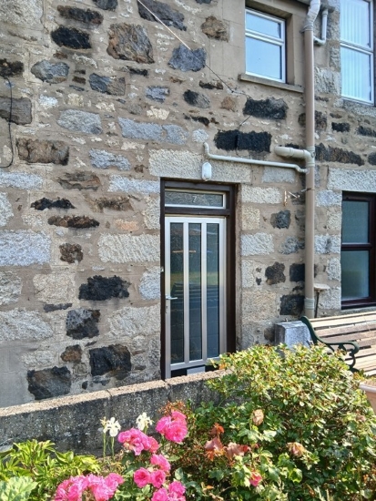 Front door or property at 7 Donalds Buildings in background with flowers in the foreground