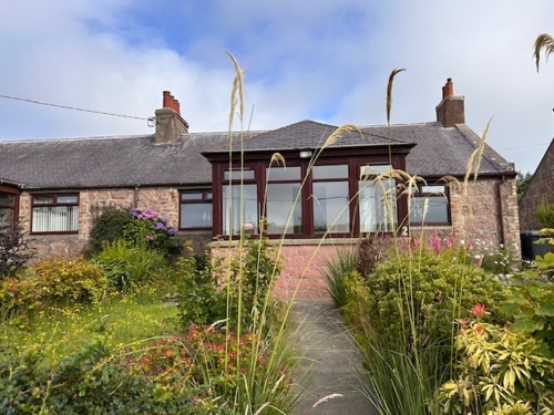 Front of semi-detached house with sunroom and front garden