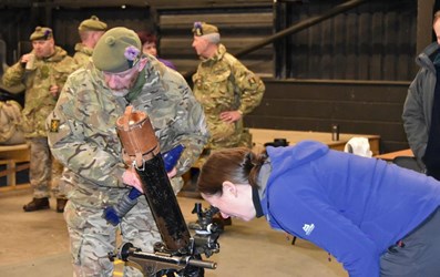 person looking at mortar bomb