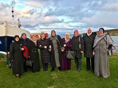 A group of Syrian refugees standing on a beach