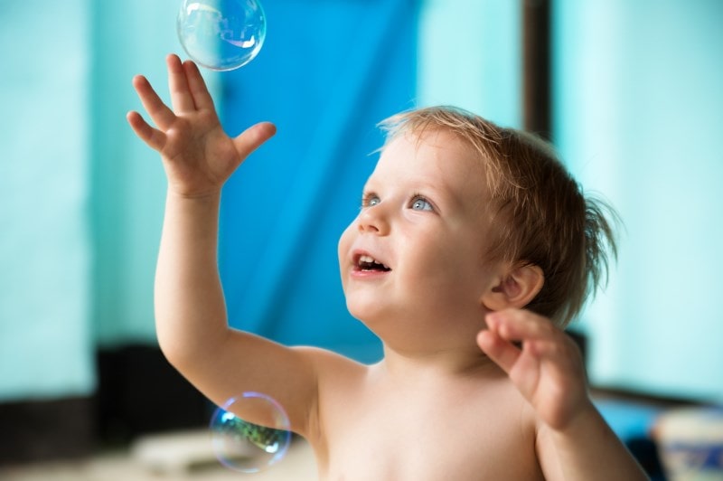 Little boy playing with soap bubbles