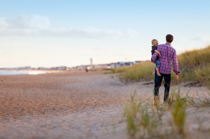 Father and child on a beach walk