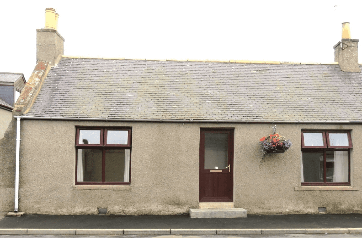 Front of 87 High Street in Cuminestown showing front door and a window on both sides of door