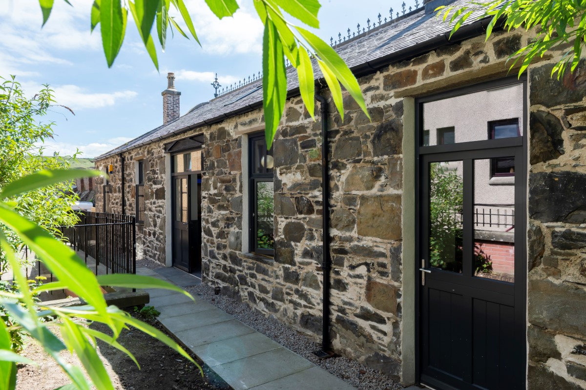 Stone building with paved path, doors and windows