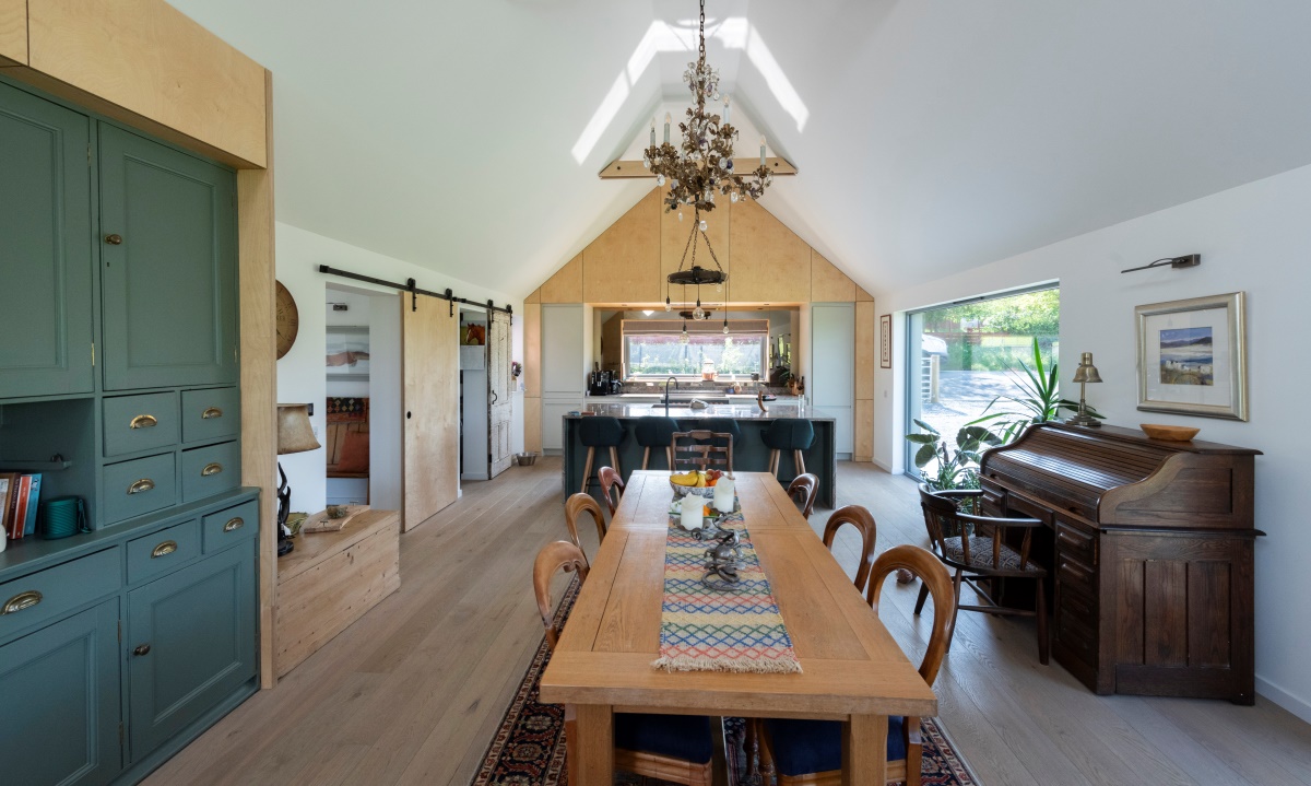 Inside Camhaniach, with long dining table, units, kitchen worktop in background