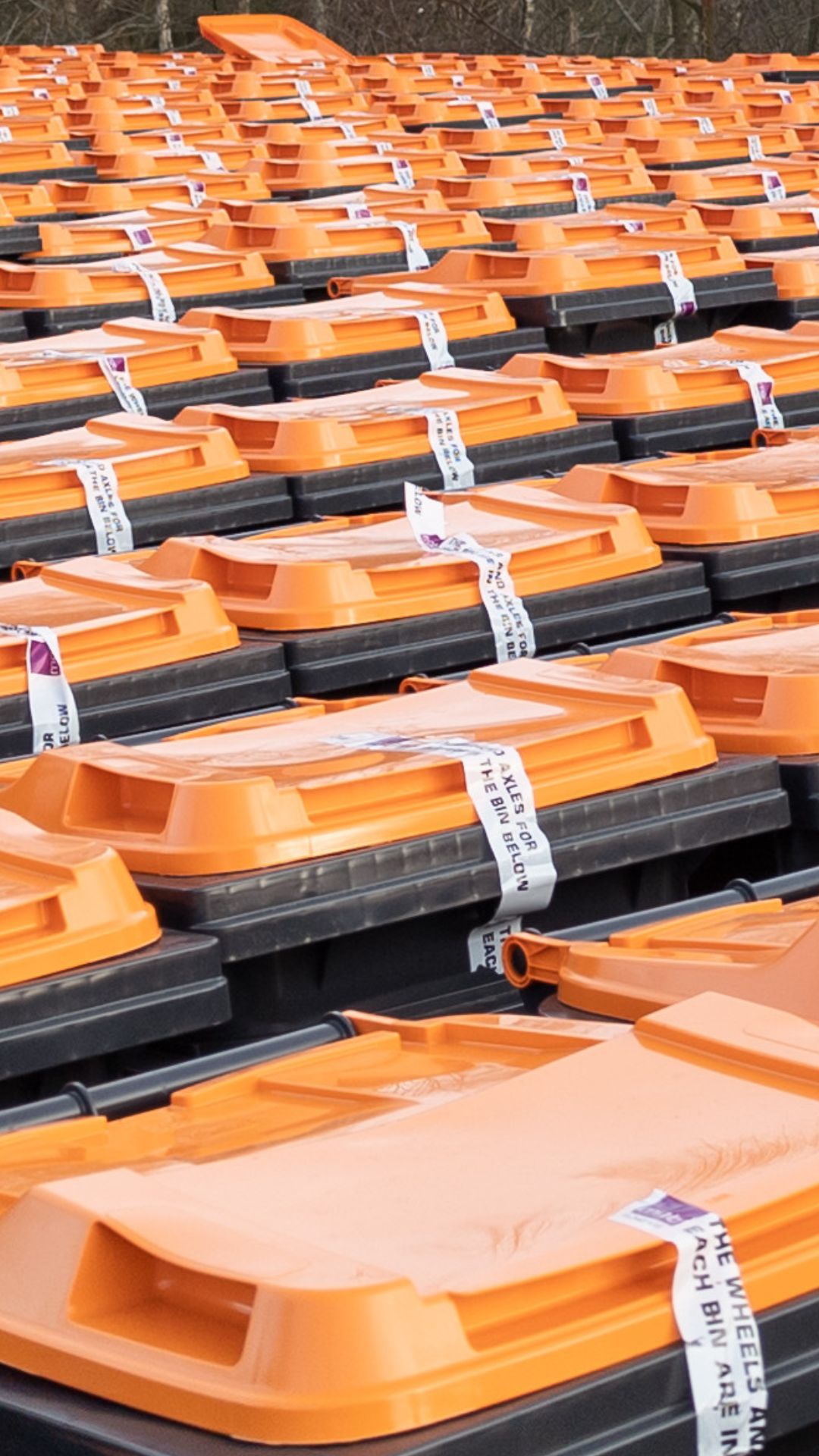 Stock of orange lid bins outside