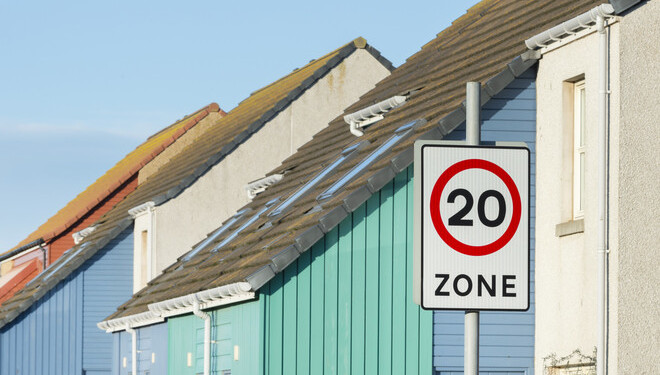 20mph zone sign with houses in the background