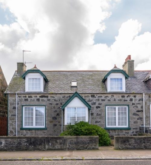 Front of semi-detached house with a small front garden with low wall.