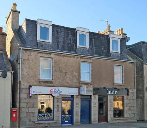 Front of building with 2 shops at street level with flats above
