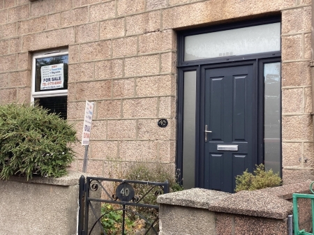 Front of property showing front door, a small garden and a gate