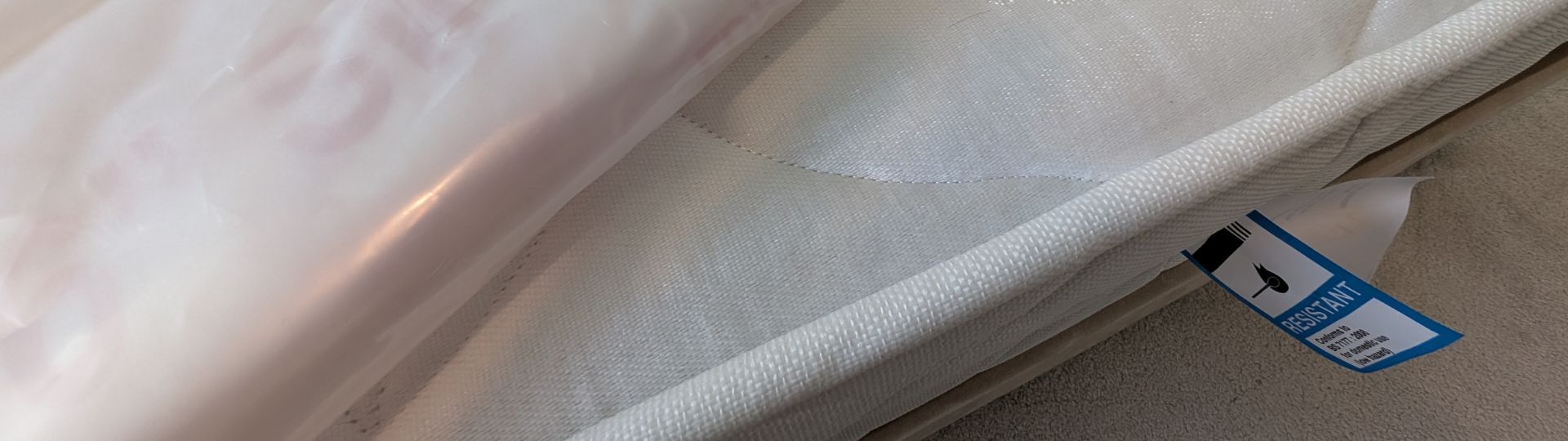 A blue fire label on a mattress with a reuse bag sitting on top.