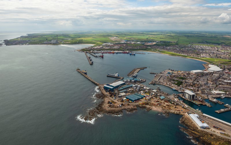 An aerial view of Peterhead harbour and bay looking south towards the Marina, Power Station and Reform Tower