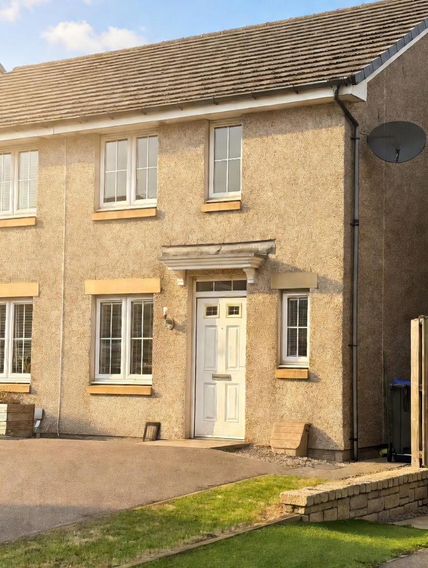 Front of the house at 10 Bothiebrigs Drive with tarmacked driveway and grass on one side